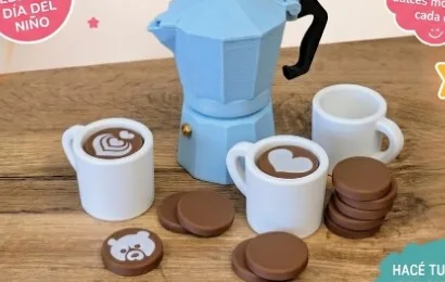 Cafetera moka celeste, tazas blancas y piezas redondas de juguete sobre mesa de madera
